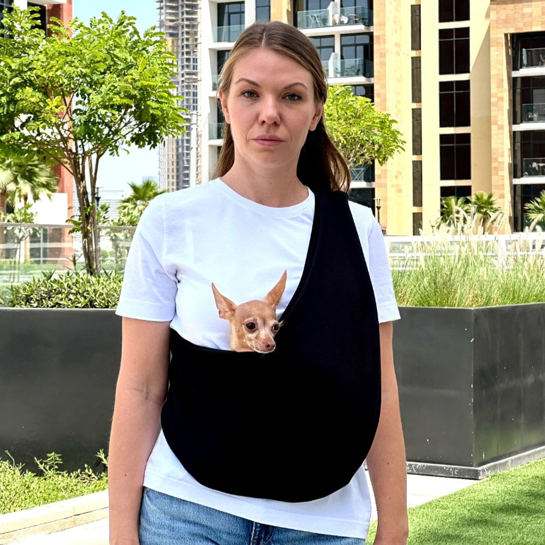 Woman wearing black dog sling carrier – hands-free pet carrier bag