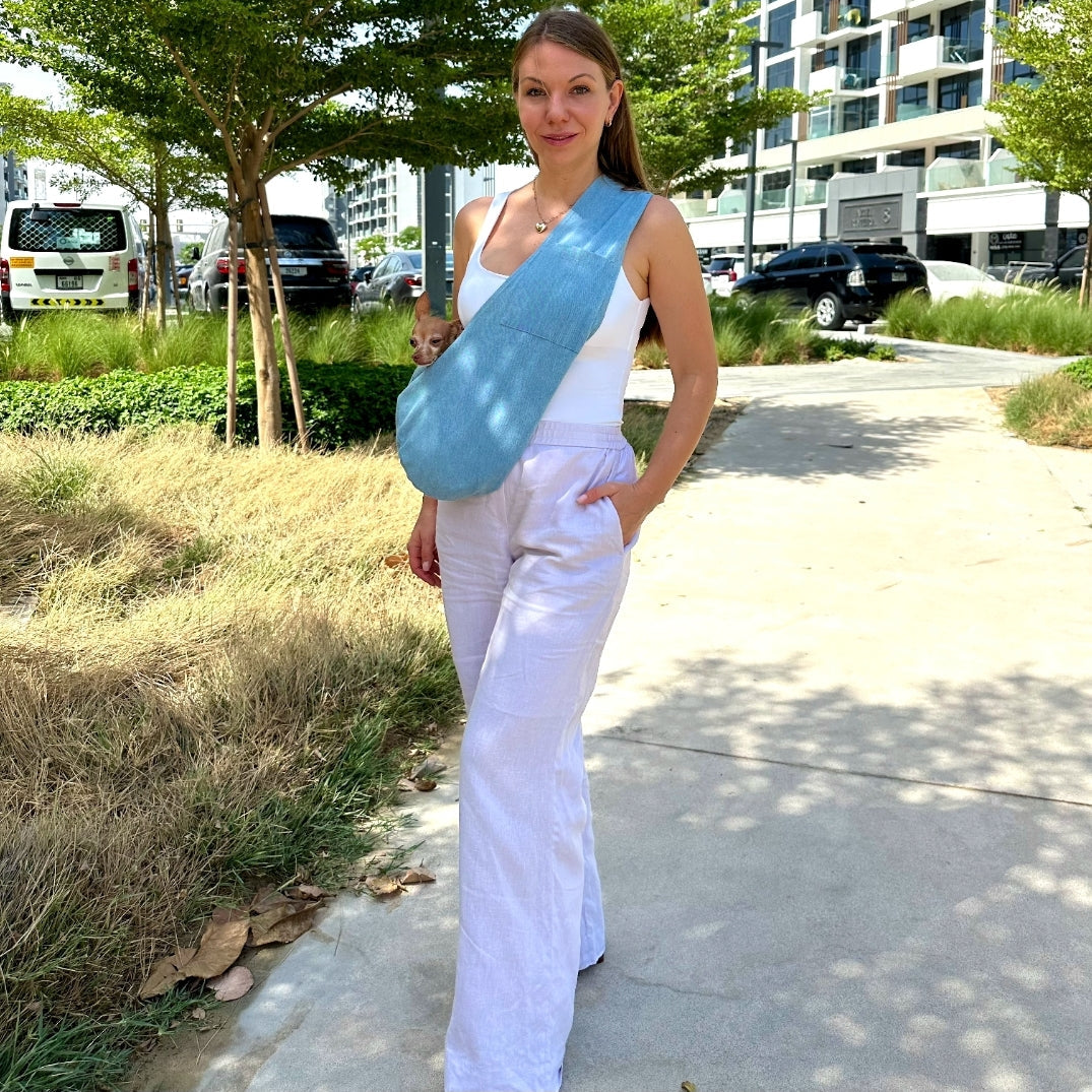 Hands-free denim dog sling bag worn by pet parent