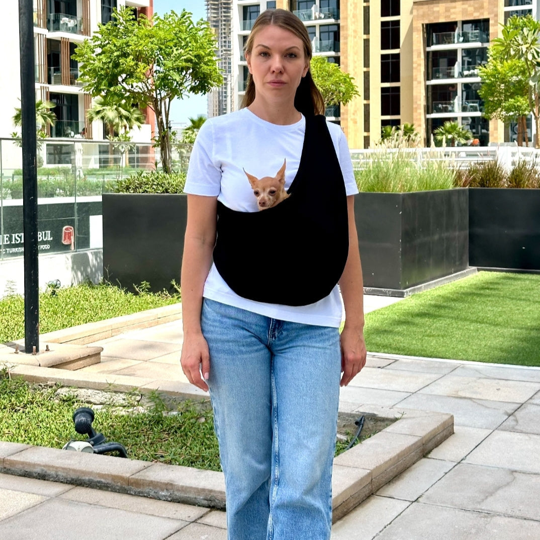 Walking with small dog in black cotton sling – summer pet carrier