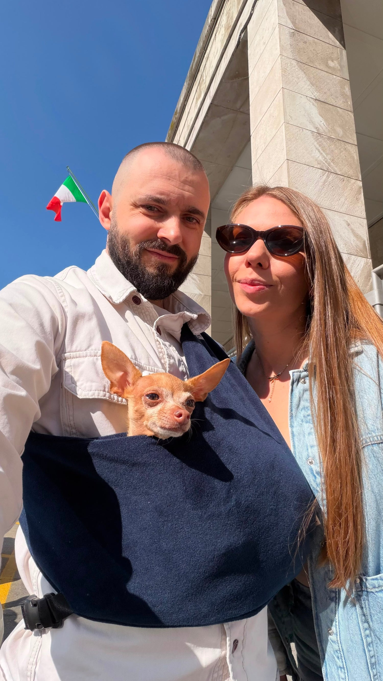 Family traveling through the city with a small dog in a Kokopaws dog sling. Comfortable hands-free pet carrier for everyday adventures and travel.